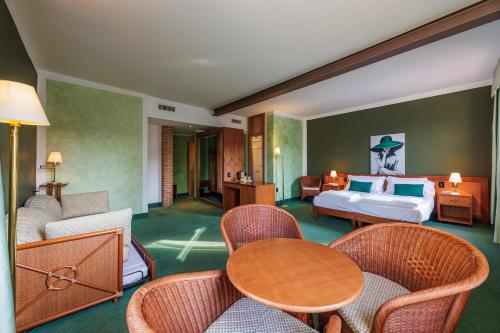 a hotel room with a bed and a table and chairs at Hotel alla Grotta in Lazise