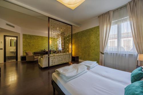 a bedroom with a bed and a living room at Hotel alla Grotta in Lazise
