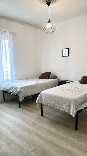 une chambre avec deux lits et un lustre dans l'établissement Flc - Charmant T3 neuf - Saint-charles 1,5km - clim et parking, à Marseille