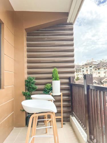 a balcony with two stools and two plants at Mi Casa Baguio in Baguio