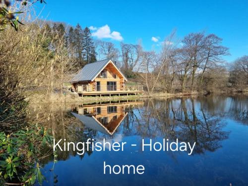 a log cabin on the water with the words kindergarten holiday home at Lake District Log Cabins in Broughton in Furness