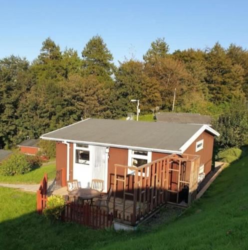 a small house with a deck on a hill at Cosy Chalet, Seasonal Pool & Play Park Llansteffan in Llangain