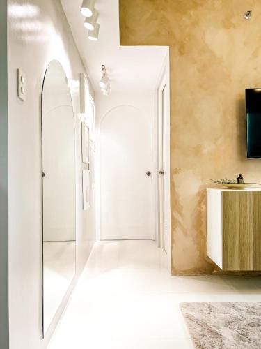 a bathroom with a glass door and a mirror at Mi Casa Baguio in Baguio