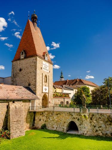an old building with a tower and a bridge at Köpplmühle Apartment in Freistadt