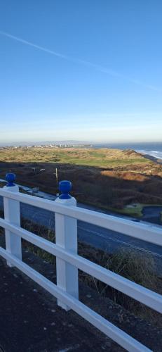 a white fence with a view of the ocean at Royal Court Hotel in Portrush