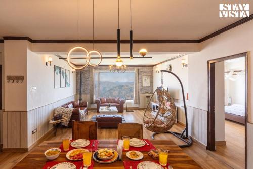 a dining room and living room with a dining table at StayVista at The Apricot with Heater & BBQ in Mashobra