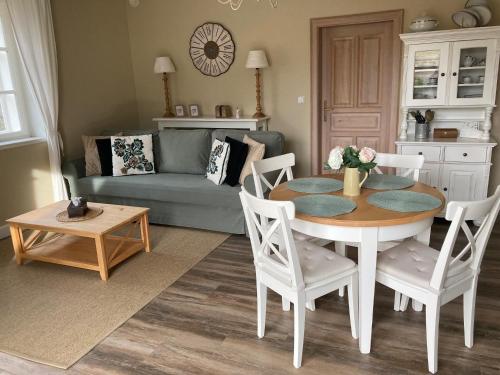 ein Wohnzimmer mit Tisch und Couch in der Unterkunft Apartmán Nad Modravou in Modrava
