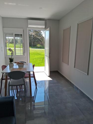 a dining room with a table and chairs and a window at Melissan Escape in Mélissa
