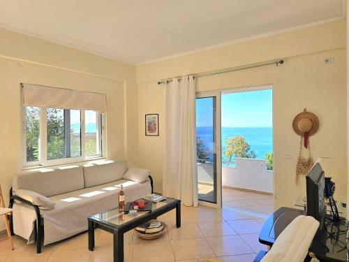 a living room with a couch and a view of the ocean at Villa Marius 074 in Qeparo