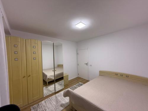 a bedroom with a bed and a mirror at Apartament me qera Gjilan,te sheshi in Gjilan