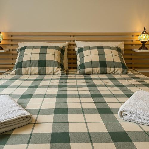 - une chambre avec deux oreillers et un sol en damier dans l'établissement Maison Provençale - Piscine & Terrain de Pétanque, à Grillon