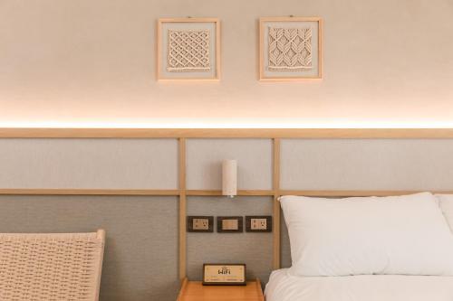 a bedroom with a bed and a clock on a table at Yuzhi Wenlv B&B in Hualien City
