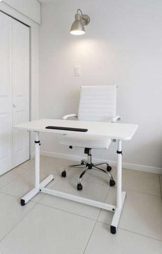 a white desk with a laptop on top of it at Modern Home - Termpurpedic Queen bed, Laundry, Free Parkging, EV Tesla in Hollywood