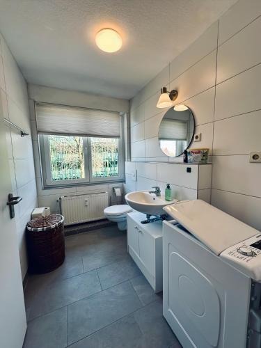a white bathroom with a sink and a toilet at FeWo Euregio III Zentral & Klinik-Nähe in Nordhorn