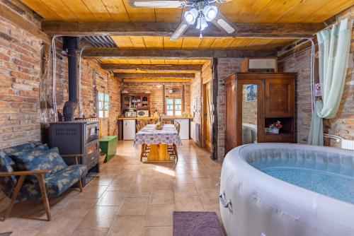 a room with a bath tub and a kitchen with a table at Kuća za odmor Pčelica & Zagorje in Sveti Križ Začretje