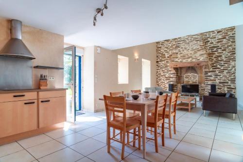Il comprend une cuisine et une salle à manger avec une table et une cheminée. dans l'établissement Longère de Kerchéré - 400m de la plage, à Clohars-Carnoët