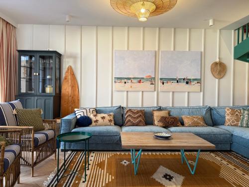 a living room with a blue couch and a table at Sea You Beach House in Rogowo