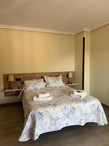 a bedroom with a bed with towels on it at Pension Reconquista in Cangas de Onís