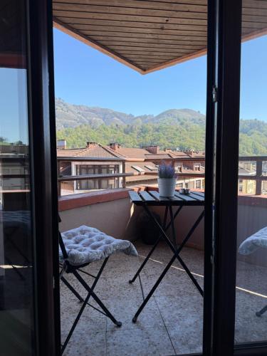 a balcony with a table and a view of a city at Pension Reconquista in Cangas de Onís