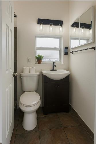 a bathroom with a toilet and a sink and a window at Modern Home - Termpurpedic Queen bed, Laundry, Free Parkging, EV Tesla in Hollywood