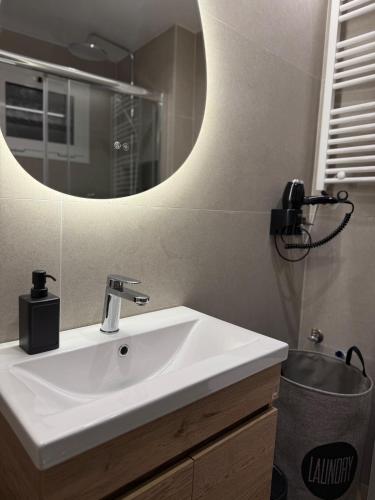 a bathroom with a white sink and a mirror at Karma - Luxury Living in Katerini