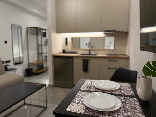 a kitchen with a table with two white plates on it at Karma - Luxury Living in Katerini