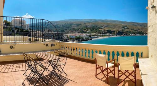 a balcony with chairs and a view of the water at Chic Magnificent Sea View Suite in Andros