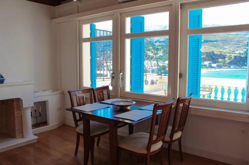 a dining room with a table and chairs and windows at Chic Magnificent Sea View Suite in Andros