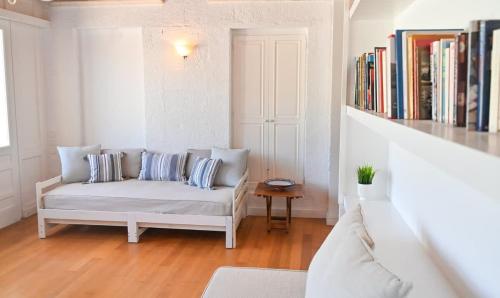 a living room with a couch and a book shelf at Chic Magnificent Sea View Suite in Andros