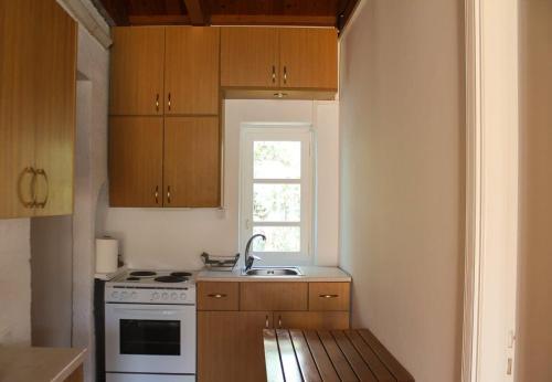 a kitchen with a stove and a sink and a window at Chic Magnificent Sea View Suite in Andros