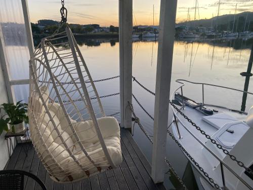 a swinging chair on a porch with a view of the water at On the water boat House in Whangarei