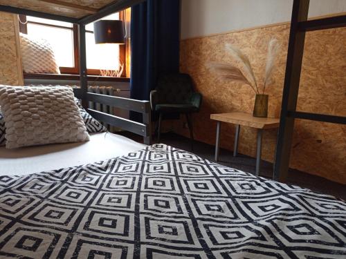 a bedroom with a bed and a chair and a window at Rooms Center - dworzec PKP, rynek Wrocław in Wrocław