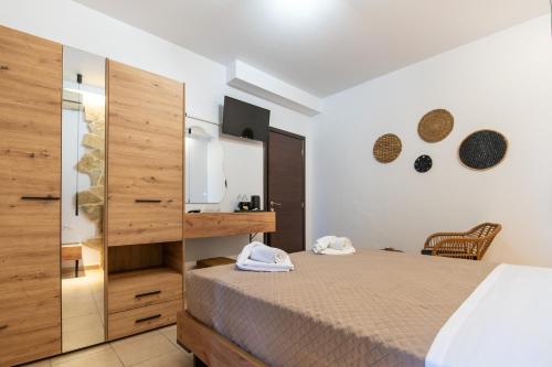a bedroom with a bed and a large wooden cabinet at Villa Gereoudis SeaView Apartments-Pool & Bar in Kolymvari