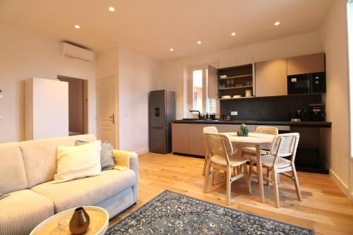 un salon avec un canapé et une table avec des chaises dans l'établissement Apartment - La Isla - Seafront, à Èze