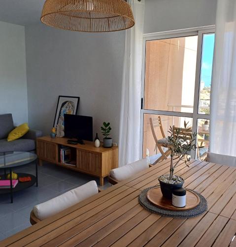 a living room with a wooden table and a living room with a couch at Apartamento en Playa Honda - La Manga in Cartagena