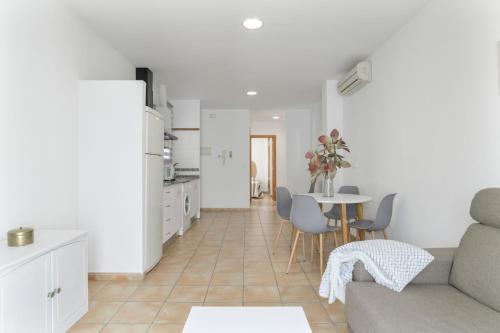 a kitchen and living room with a couch and a table at Apartamento Perez Zara 7 in Conil de la Frontera