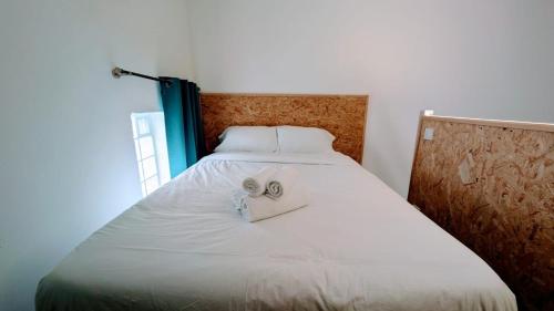 - un lit blanc avec 2 serviettes pliantes dans l'établissement Studio COSY indépendant avec MEZZANINE - CALME à Gif-sur-Yvette, à Gif-sur-Yvette