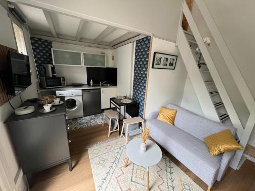 un petit salon avec un canapé et une table dans l'établissement Studio COSY indépendant avec MEZZANINE - CALME à Gif-sur-Yvette, à Gif-sur-Yvette