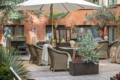a patio with wicker chairs and an umbrella at Best Western Hotel Hebron in Copenhagen