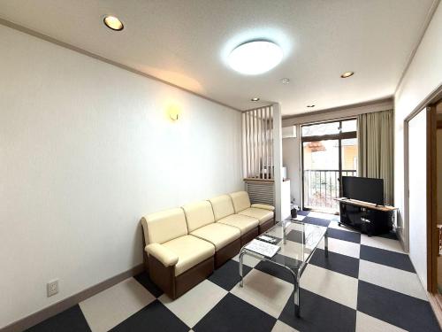 a living room with a couch and a tv at 楓リゾート鬼怒川温泉 优雅宽敞的日式独栋旅馆 in Nikko