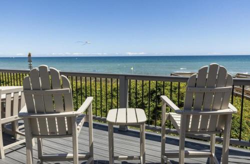 two chairs sitting on a deck looking at the ocean at Oceans 6 condo in Pine Knoll Shores