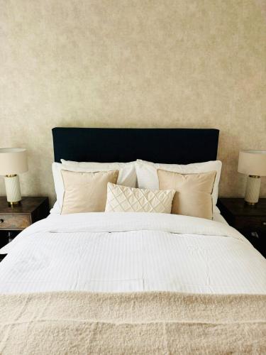 a large white bed with pillows and two lamps at Spacious Maidstone 2Bed 2Bath - Parking & Balcony - Perfect for Family & Contractors in Maidstone