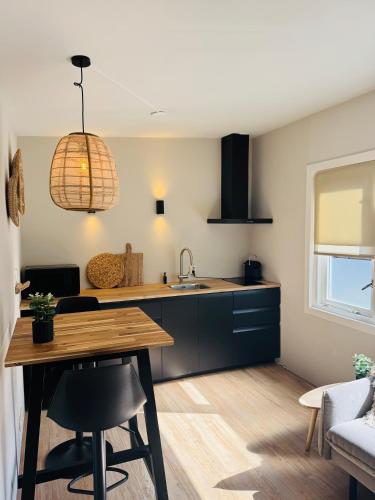 a kitchen with a sink and a table in a room at Willem's Beachhouse in Noordwijk