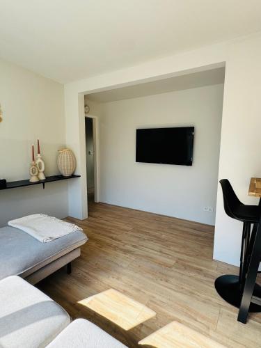 a living room with a couch and a television on a wall at Willem's Beachhouse in Noordwijk