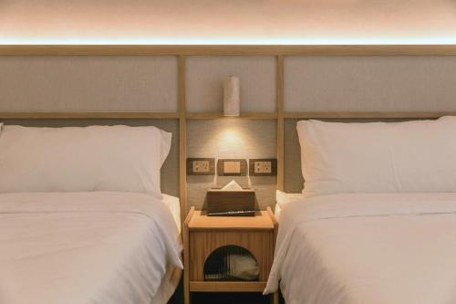 a bedroom with two beds and a night stand with a nightstand between them at Yuzhi Wenlv B&B in Hualien City