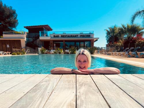 une femme assise sur une table dans une piscine dans l'établissement Traum mit Meerblick, à Saint-Raphaël