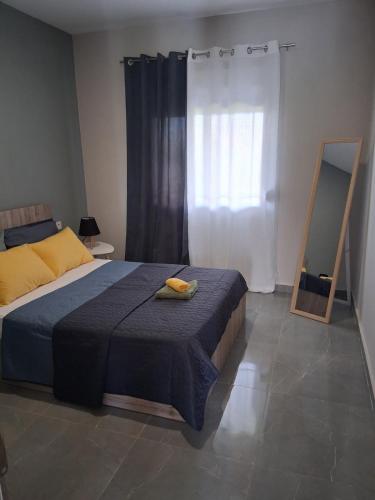 a bedroom with a bed with a blue blanket and a mirror at Melissan Escape in Mélissa