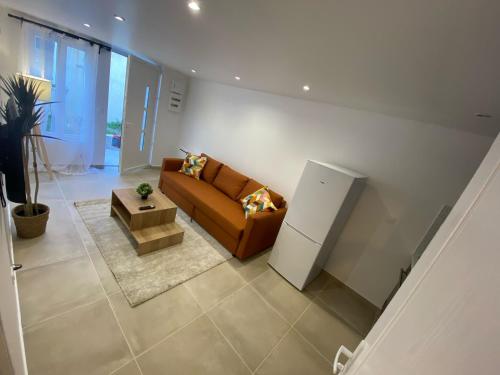 a living room with a couch and a refrigerator at G-Logement-Francilien Villa Parc des expositions Villepinte, Bourget, Astérix , Paris in Goussainville