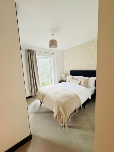 a bedroom with a large bed and a window at Spacious Maidstone 2Bed 2Bath - Parking & Balcony - Perfect for Family & Contractors in Maidstone