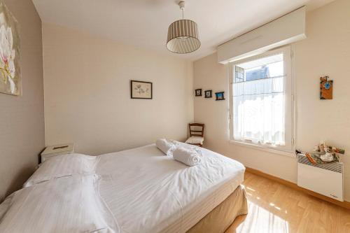 une chambre avec un lit blanc et une fenêtre dans l'établissement Le Dinarzh - 500m plage - Terrasse, à Dinard